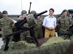 Prime Minister Justin Trudeau takes part in a vehicle display by Slovakian troops as he visits the Adazi Military Base in Kadaga, Latvia, on Tuesday, July 10, 2018.