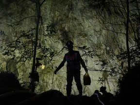 Rescuers make their way down at the entrance to a cave complex where 12 boys and their soccer coach went missing, in Mae Sai, Chiang Rai province, in northern Thailand, Sunday, July 1, 2018. The frantic effort to locate them in the cave for a week picked up pace as a break in the rain eased flooding in the system of caverns and more experts from around the world joined the anxious rescue mission.