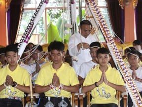 Soccer coach Ekkapol Janthawong, second from left, and members of the rescued soccer team attend a Buddhist ceremony that is believed to extend the lives of its attendees as well as ridding them of dangers and misfortunes in Mae Sai district, Chiang Rai province, northern Thailand, Thursday, July 19, 2018. The 12 boys and their soccer coach rescued from a cave in northern Thailand left the hospital where they had been recuperating and appeared at a news conference Wednesday, saying the ordeal made them stronger and taught them not to live carelessly.