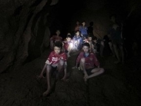 This Monday, July 2, 2018, photo released by Tham Luang Rescue Operation Center, shows the boys and their soccer coach as they were found in a partially flooded cave, in Mae Sai, Chiang Rai, Thailand. The 12 boys and coach found  after 10 days are mostly in stable medical condition and have received high-protein liquid food, officials said Tuesday, though it is not known when they will be able to go home. (Tham Luang Rescue Operation Center via AP)