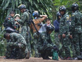 Thai rescuers prepare to enter the cave where 12 boys and their soccer coach have been trapped since June 23, in Mae Sai, Chiang Rai province, in northern Thailand Friday, July 6, 2018. Thai authorities are racing to pump out water from the flooded cave before more rains are forecast to hit the northern region.