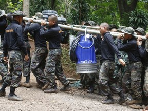 Soldiers carry a pump to help drain the rising flood water in a cave where 12 boys and their soccer coach have been trapped since June 23, in Mae Sai, Chiang Rai province, in northern Thailand Friday, July 6, 2018. Thai authorities are racing to pump out water from the flooded cave before more rains are forecast to hit the northern region.