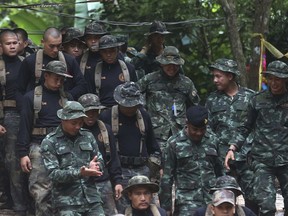 Thai soldiers makes their way down at the entrance to a cave complex where 12 boys and their soccer coach were trapped inside when heavy rains flooded the cave, in Mae Sai, Chiang Rai province, in northern Thailand, Wednesday, July 4, 2018. The Thai soccer teammates stranded more than a week in a partly flooded cave said they were healthy on a video released Wednesday, as heavy rains forecast for later this week could complicate plans to safely extract them.