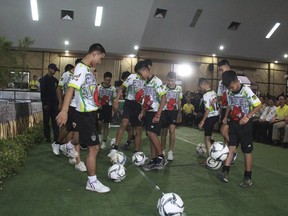 In this July 18, 2018, photo provided by Chiang Rai Public Relations Department, members of the rescued soccer team show their skills before a press conference regarding their experience being trapped in the cave in Chiang Rai, northern Thailand. The Thai soccer boys and their coach began their first day back home with their families since they were rescued from a flooded cave with a trip to a Buddhist temple on Thursday, July 19,  to pray for protection from misfortunes. (Chiang Rai Public Relations Department via AP)