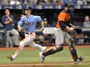 Tampa Bay Rays' Joey Wendle, left, runs past Houston Astros catcher Max Stassi to score on Matt Duffy's single during the seventh inning of a baseball game Sunday, July 1, 2018, in St. Petersburg, Fla.