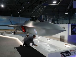 Visitors look at the model of a new fighter jet, a part of Team Tempest, during the Farnborough Airshow, south west of London, on July 16, 2018.