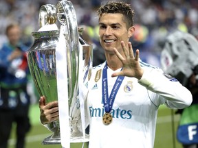 FILE - In this Saturday, May 26, 2018 file photo Real Madrid's Cristiano Ronaldo celebrates with the trophy after winning the Champions League Final soccer match between Real Madrid and Liverpool at the Olimpiyskiy Stadium in Kiev, Ukraine.