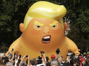 A six-meter high cartoon baby blimp of U.S. President Donald Trump is flown as a protest against his visit, in Parliament Square in London, England, Friday, July 13, 2018. Trump is making his first trip to Britain as president after a tense summit with NATO leaders in Brussels and on the heels of ruptures in British Prime Minister Theresa May's government because of the crisis over Britain's exit from the European Union.