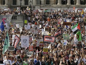 Protestors holding banners gather after a march opposed to the visit of U.S. President Donald Trump in Trafalgar Square in London, Friday, July 13, 2018. Trump's pomp-filled welcome to Britain was overshadowed Friday by an explosive interview in which he blasted Prime Minister Theresa May, blamed London's mayor for terror attacks against the city and argued that Europe was "losing its culture" because of immigration. In rear is the The National Gallery.