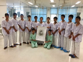 This handout photo released by the Ministry of Health, Chiang Rai Prachanukroh Hospital on July 15, 2018 and taken on July 14 shows members of the rescued "Wild Boars" football team at hospital in Chiang Rai province posing after writing messages on a drawing of former Navy SEAL diver Saman Kunan who died on July 6 during the rescue mission. The 12 boys and their coach rescued from the Thai cave mourned the death of the ex-Navy SEAL who died while taking part in the mission, the health ministry said on July 15.