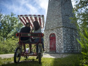 Couple Mehdi Labonne, left, and Monica Kulik take a break from their bike ride at the Gibraltar Point Lighthouse at Toronto Island on Thursday, June 21, 2018.