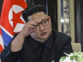 FILE - In this June 12, 2018, file photo, North Korea leader Kim Jong Un adjust his glasses after signing documents with U.S. President Donald Trump at the Capella resort on Sentosa Island in Singapore. North Korea's state-run media have toned down their rhetorical attacks on the United States and South Korea while leader Kim Jong Un pursues a more diplomatic approach, but the vitriol continues, and Japan is now Pyongyang's favorite foil.