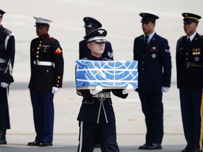 A soldier carries a casket containing a remain of a U.S. soldier who was killed in the Korean War during a ceremony at Osan Air Base in Pyeongtaek, South Korea, Friday, July 27, 2018.  The U.N. Command said the 55 cases of war remains retrieved from North Korea will be honored at a ceremony next Wednesday at a base in South Korea.