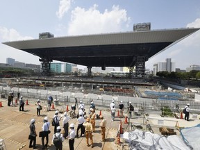 In this July 24, 2018, photo, journalists tour the Olympic Aquatics Center under the construction, in Tokyo. Organizers of the 2020 Tokyo Olympics insist that construction delays at two key venues will have no impact on preparations for the games including test events. The Tokyo Metropolitan Government announced last month that construction of the Olympic Aquatics Center and the Sea Forest Waterway will be delayed by two months.