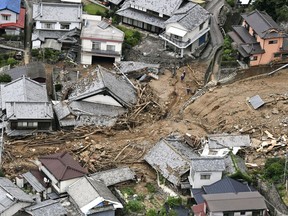 Houses are damaged by mudslide following heavy rains in Kure city, Hiroshima prefecture, southwestern Japan, Saturday, July 7, 2018.