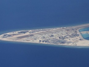 FILE - In this April 21, 2017, file photo, an airstrip, structures and buildings on China's man-made Subi Reef in the Spratly chain of islands in the South China Sea are seen from a Philippine Air Force C-130 transport plane of the Philippine Air Force. Southeast Asian nations are expected to welcome an initial negotiating draft of a nonaggression pact with China on the South China Sea, but critics warn that the protracted talks provide a diplomatic cover for Beijing's tenacious aggression in the disputed waters. Four days of annual summitry in Singapore starts Wednesday, Aug. 1, 2018.