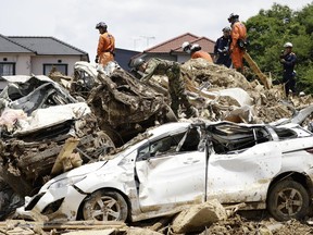 Rescuers work at a mudslide area during a search operation in Kumano town, Hiroshima prefecture, southwestern Japan, Wednesday, July 11, 2018. Rescuers were combing through mud-covered hillsides and along riverbanks Tuesday searching for dozens of people missing after heavy rains unleashed flooding and mudslides in southwestern Japan.