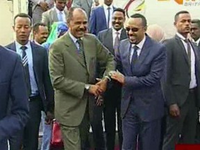 FILE - In this , July 8, 2018, file image from video provided by ERITV, Ethiopia's Prime Minister Abiy Ahmed, center right, is welcomed by Eritrea's President Isaias Afwerki as he disembarks the plane, in Asmara, Eritrea. Afwerki is visiting Ethiopia on Saturday, July 14, 2018, the latest step in an unprecedented diplomatic thaw between the former archrivals. Eritrea's Information Minister Yemane Gebremeskel confirms the visit on Twitter, saying it will "add momentum to the joint march for peace and cooperation." (ERITV via AP, File)