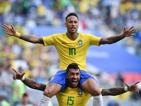 Brazil forward Neymar (top) celebrates his goal against Mexico with midfielder Paulinho at the World Cup on July 2.