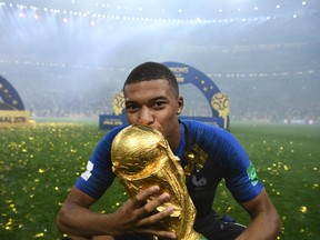 France forward Kylian Mbappe kisses the World Cup trophy in Moscow on July 15.