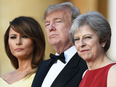 U.S. First Lady Melania Trump, U.S. President Donald Trump and Britain's Prime Minister Theresa May watch a ceremonial welcome as they arrive for a black-tie dinner at Blenheim Palace, west of London, on July 12, 2018, on the first day of Trump's U.K. visit.