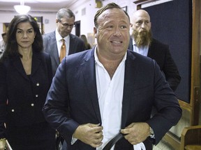 FILE - In this April 17, 2017, file photo, "Infowars" host Alex Jones arrives at the Travis County Courthouse in Austin, Texas. Jones filed a motion Friday, July 20, 2018, to dismiss a defamation lawsuit filed by families of some of the 26 people killed in the 2012 Sandy Hook school shooting in Newtown, Conn. Lawyers for Jones argued he was acting as a journalist in questioning the official narrative of the shooting. Jones, who said he now believes the shootings happened, said such journalism would be chilled if "reporters were subject to liability if they turned out to be wrong."