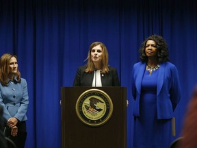 U.S. Attorney Erin Nealy Cox, center, holds a news conference on Friday, July 13, 2018 in Dallas.  Federal prosecutors say eight MS-13 members have been indicted in Texas on charges tied to alleged gang activities including racketeering conspiracy, attempted murder and assault.  Cox announced the charges.  Officials describe the gang as one of the most ruthless and violent on the streets.