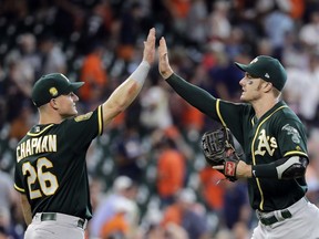 Oakland Athletics' Matt Chapman (26) and Mark Canha celebrate after a baseball game against the Houston Astros Thursday, July 12, 2018, in Houston. The Athletics won 6-4.