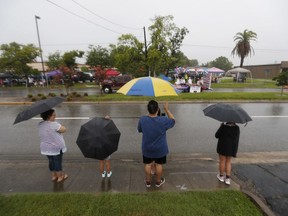People watch the Friendswood Grand Parade during heavy rain on Wednesday, July 4, 2018, in Friendswood, Texas.