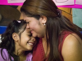 FILE - In this July 13, 2018, file photo, Allison, 6, and her mother Cindy Madrid share a moment during a news conference in Houston, where the mother and daughter spoke about the month and one day they were separated under the President Donald Trump administration immigration policy. The Trump administration is due back in court Monday, July 16, 2018, to discuss a plan reunify more than 2,500 children who were separated at the border from their parents.