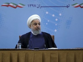 In this photo released by official website of the office of the Iranian Presidency, President Hassan Rouhani attends a meeting with a group of foreign ministry officials in Tehran, Iran, Sunday, July 22, 2018. Rouhani warned President Donald Trump against provoking his country while indicating peace between the two nations might still be possible. (Iranian Presidency Office via AP)
