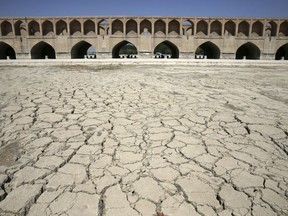 In this Tuesday, July 10, 2018 photo, the Zayandeh Roud river no longer runs under the 400-year-old Si-o-seh Pol bridge, named for its 33 arches, in Isfahan, Iran. Farmers in central Iran are increasingly turning to protests, pleading to authorities for a solution as years of drought and government mismanagement of water destroy their livelihoods. Their complaints come at a time when protests have repeatedly broken out over economic woes in Iran.