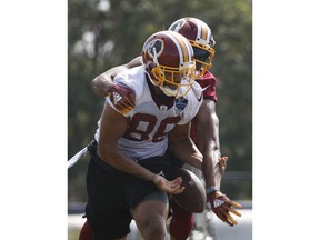 Washington Redskins defensive back Josh Norman, back, knocks the ball form the grasp of tight end Jordan Reed (86) during the morning session of NFL football training camp in Richmond, Va., Friday, July 27, 2018.