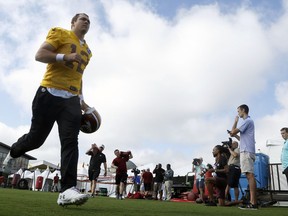 Washington Redskins quarterback Colt McCoy runs to the field at the start of NFL football training camp in Richmond, Va., Thursday, July 26, 2018.