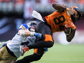 Winnipeg Blue Bombers' Adam Bighill, left, tackles B.C. Lions' Emmanuel Arceneaux during the first half of a CFL football game in Vancouver on Saturday July 14, 2018.