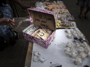 A street vendor opens a box of Bolivar banknotes at a stand in the Petare slum of Caracas, Venezuela, on April 14, 2018.