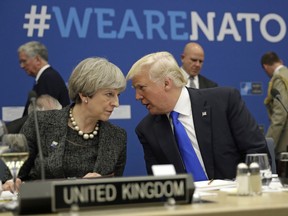 FILE -In this Thursday, May 25, 2017 file photo, British Prime Minister Theresa May, left, speaks to U.S. President Donald Trump during a NATO summit at NATO headquarters in Brussels. When Donald Trump walks into a NATO summit Wednesday, July 11, 2018,  international politics are bound to become intensely personal _ again.