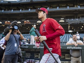 Los Angeles Angels' Shohei Ohtani takes to the field to warm up for the team's baseball game against the Seattle Mariners, Tuesday, July 3, 2018, in Seattle.