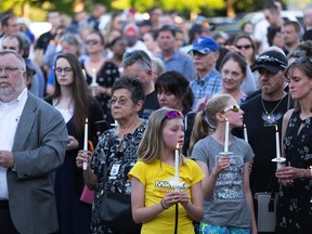Candles are lit for Kent Police Officer Diego Moreno at a vigil, Wednesday, July 25, 2018 in Kent, Wash. A vigil and memorial for fallen Kent Police Officer Diego Moreno was held at Town Square Plaza. Three teenage suspects have been charged in the fatal police chase that led to a suburban Seattle officer being struck and killed by another pursuing officer in a patrol car.