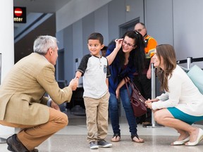 FILE - In this July 14, 2018, file photo, Jelsin Aguilar Padilla shakes immigration attorney Jorge L. Baron's hand after stepping off his flight from New York into the Seattle-Tacoma International Airport as he is reunited with his mother Yolany in Seattle. The Trump administration is due back in court Monday, July 16, 2018, to discuss a plan reunify more than 2,500 children who were separated at the border from their parents.