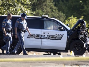 Washington State patrolmen investigate the scene where a Kent police officer was killed while trying to deploy spike strips in an effort to stop a fleeing driver, early Sunday July 22, 2018, in Kent, Wash. Authorities say the officer was apparently struck and killed by another officer who was pursuing the suspect vehicle.