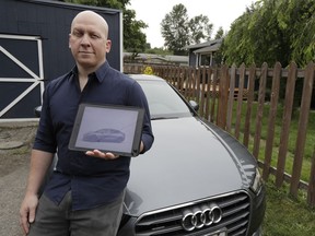 In this June 27, 2018, photo, Christian Kingery poses for a photo at his home in Preston, Wash., near Seattle, next to the leased Audi he is driving until he can take delivery of a long-awaited Tesla Model 3, which is shown on his tablet computer. Kingery, who is on an official waiting list for his car, says Tesla has told him it could take until between September and November of 2018 for his car to be delivered, but he fears it might be even longer.