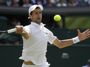 Novak Djokovic of Serbia returns the ball to Kei Nishikori of Japan during their men's quarterfinal match at the Wimbledon Tennis Championships in London, Wednesday July 11, 2018.