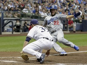 Milwaukee Brewers' Corbin Burnes tags out Los Angeles Dodgers' Clayton Kershaw during the fifth inning of a baseball game Saturday, July 21, 2018, in Milwaukee. Kershaw tried to score from third on a pitch that got passed catcher Erik Kratz.