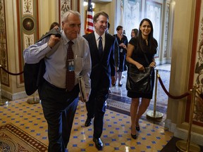 In this July 11, 2018, photo, Supreme Court nominee Brett Kavanaugh is escorted by former Sen. Jon Kyl, R-Ariz., to a meeting on Capitol Hill in Washington. Kyl is back in the Senate, this time as Kavanaugh's confirmation Sherpa. The former senator from Arizona retired in 2013 to become a lobbyist. But the White House and Senate Republicans named him as the guide for President Donald Trump's nominee to the Supreme Court even before Trump had nominated Kavanaugh.