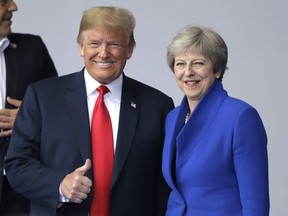 In this July 11, 2018, photo, U.S. President Donald Trump, left, talks to British Prime Minister Theresa May during a summit of heads of state and government at NATO headquarters in Brussels. Trump is all in for Winston Churchill during his first visit to the United Kingdom as president, paying his respects to an icon of American conservatives who coined the phrase the "special relationship." Trump will join May for a black-tie dinner Thursday at Blenheim Palace, Churchill's birthplace near Oxford, at the start of his trip to England.