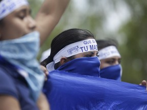 Masked women take part in a demonstration supporting journalists recently attacked while covering protests demanding the resignation of President Daniel Ortega and the release of all political prisoners, in Managua, Nicaragua, Monday, July 30, 2018.