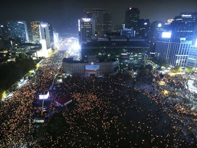 FILE - In this Nov. 12, 2016, file photo, people holding candle lights stage a rally calling for South Korean President Park Geun-hye to step down in Seoul, South Korea. South Korean President Moon Jae-in's office said Tuesday, July 10, 2018, that Moon has ordered an investigation into an allegation that the military drew up a plan to mobilize troops if protests worsened over the fate of his impeached predecessor last year.