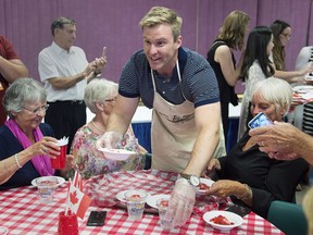 New Brunswick Premier Brian Gallant hands out some treats at a strawberry social as the Canadian premiers meet in St. Andrews, N.B., on Thursday, July 19, 2018.