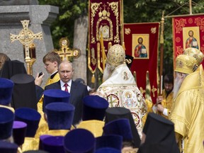 Russian President Vladimir Putin, center, attends a ceremony marking the 1,030th anniversary of the adoption of Christianity by Prince Vladimir, the leader of Kievan Rus, a loose federation of Slavic tribes that preceded the Russian state in Moscow, Russia, Saturday, July 28, 2018. Speaking to a crowd of thousands of clergy and believers at a huge statue of the prince outside the Kremlin, Putin said adopting Christianity was "the starting point for the formation and development of Russian statehood, the true spiritual birth of our ancestors, the determination of their identity.